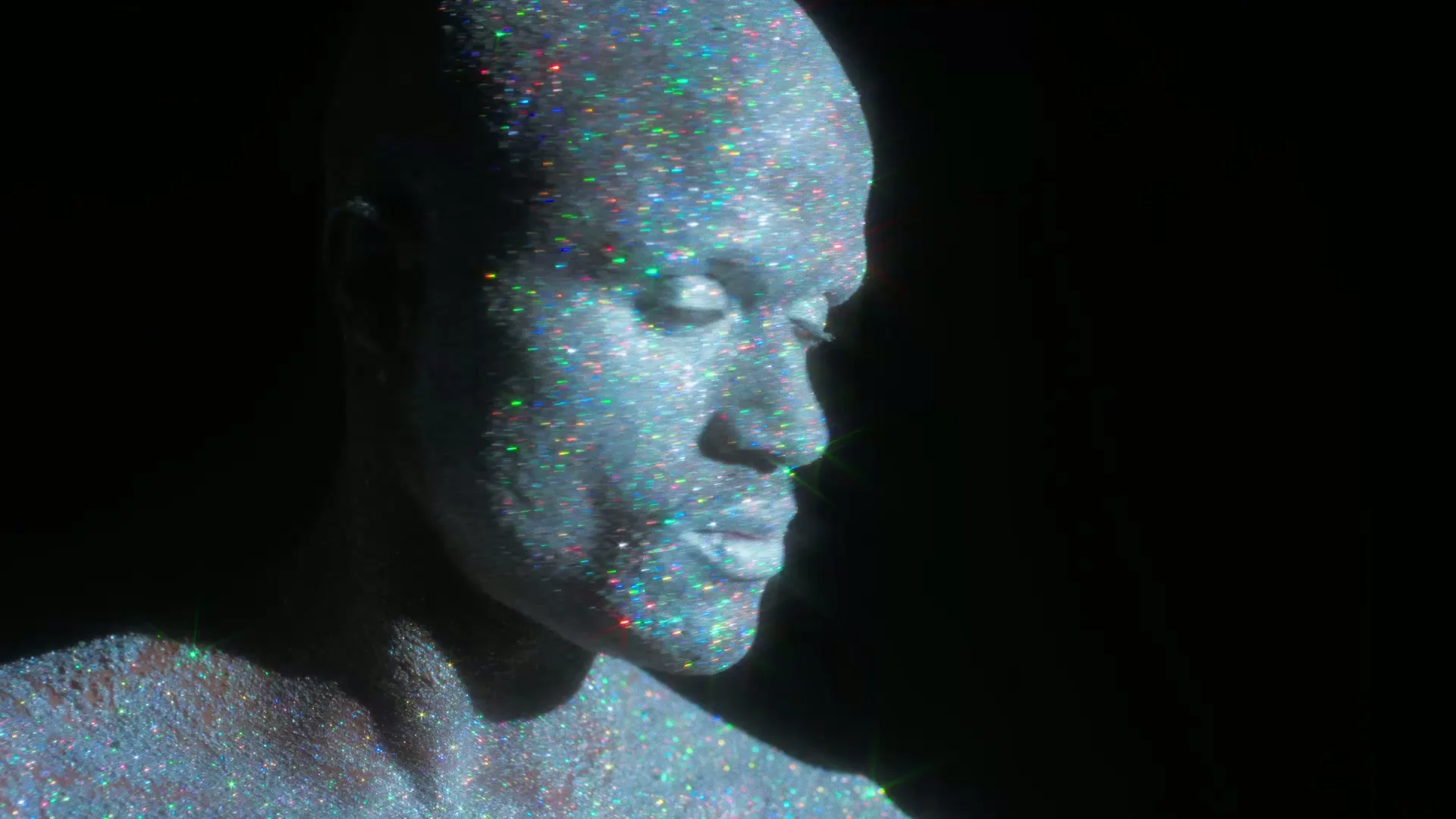 Blue and multicoloured points of light cover the portrait.