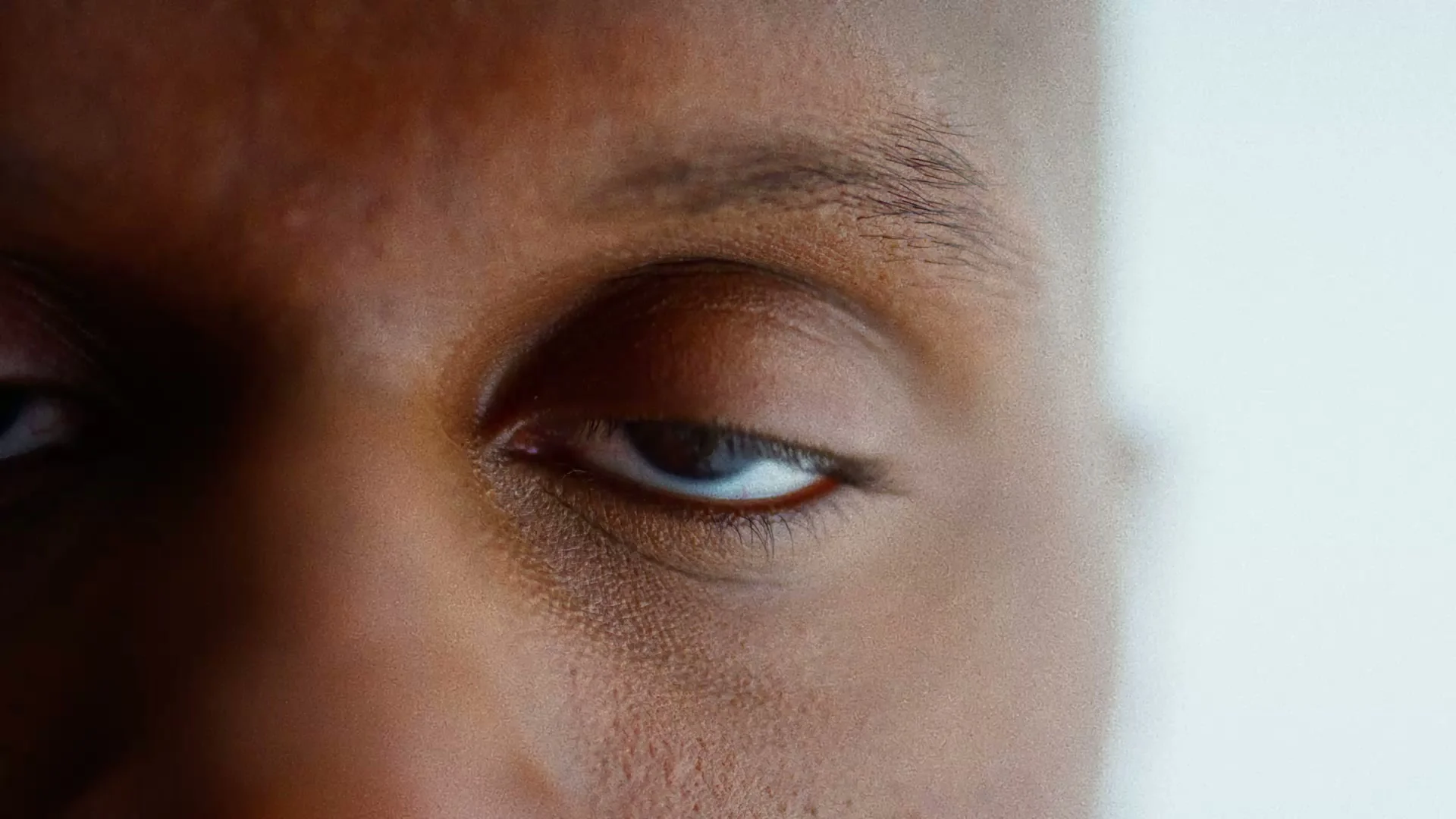 Close-up of an eye, between shadow and light.