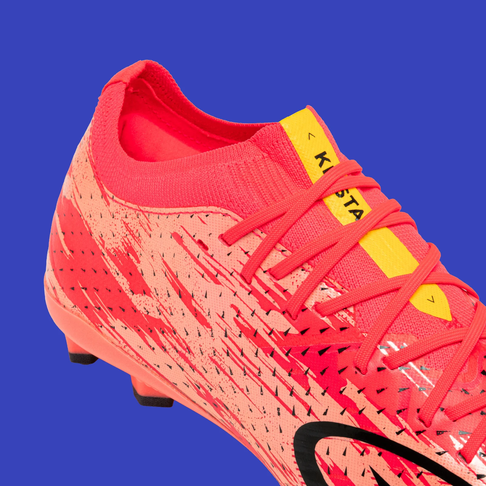 Close-up of the pink upper and laces on the Kipsta CLR Red Storm, with a yellow strip on the tongue.