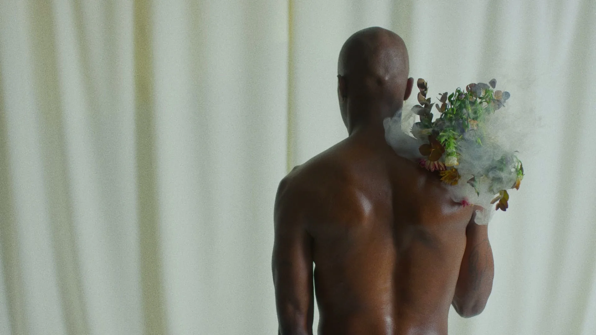 A smoking bouquet is held in front of a face.